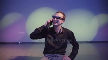 Kendine güvenen adam cep telefonuyla konuşan bir gece kulübünde