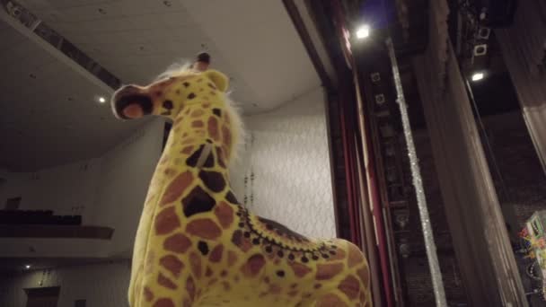 Toy Giraffe stands swinging on the theatrical stage — Stock Video