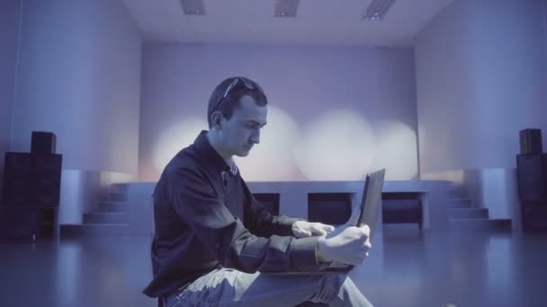 Человек, работающий за ноутбуком, один на танцполе — стоковое видео
