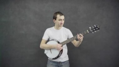 Genç adam banço çalıyor. Siyah arka plan