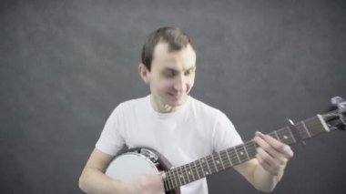 Genç adam banço çalıyor. Siyah arka plan