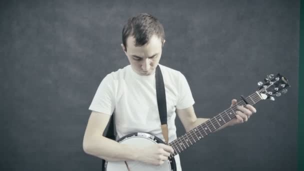 Jonge man speelt de banjo. Zwarte achtergrond — Stockvideo