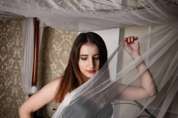 Bir beyaz erkek gömlek ve siyah sütyen reklam külot giymiş seksi kadın yatakta oturur