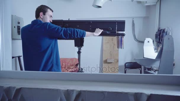 Mann zeigt Maschinengewehr in einem Bunker mit einem Verfolgungsspot — Stockvideo