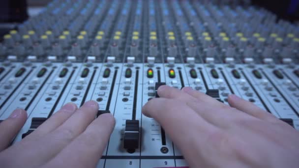 Руки звукоинженера работы с фэйдерами и ручками на профессиональном аудио миксере — стоковое видео