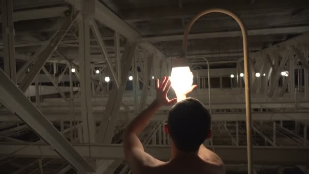 神奇的光。太阳镜的裸体男人钦佩灯泡 — 图库视频影像