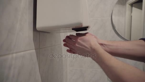 Man dry hands on modern hand dryer in toilet — Stock Video