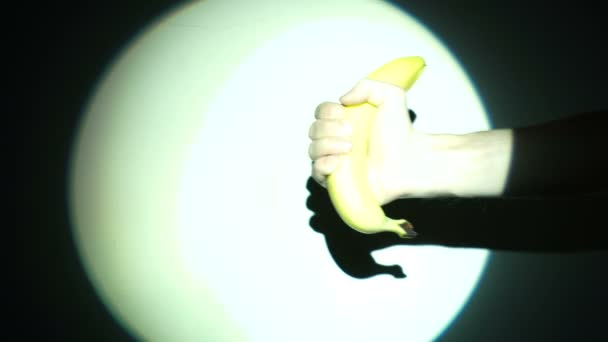 Banan i handen i rampljuset — Stockvideo
