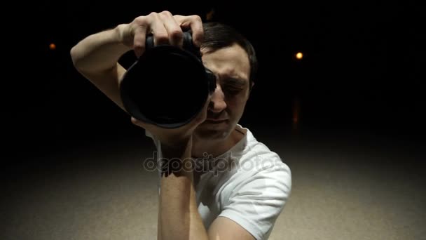Młody mężczyzna fotograf, sfotografowany na dslr aparat fotograficzny — Wideo stockowe