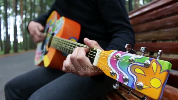 Парень играет на гитаре в стиле хиппи — стоковое видео