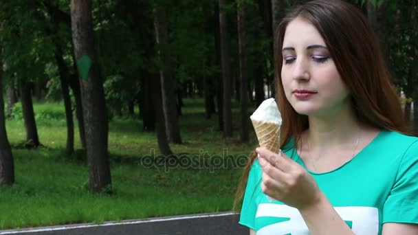 Femme mignonne manger de la crème glacée dans le parc — Video