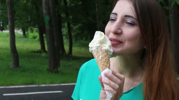 Ładna kobieta jedzenie lodów w parku — Wideo stockowe