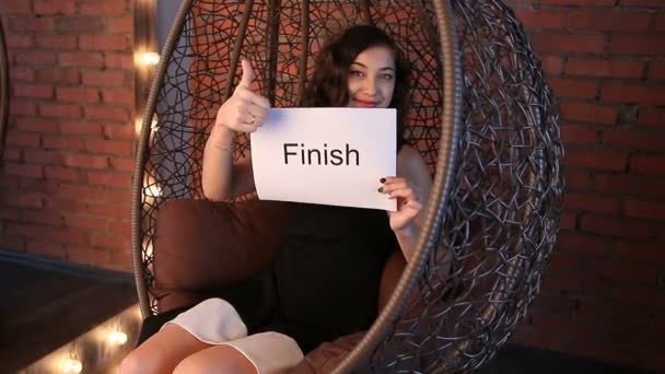 Ung flicka visar inskriptionen: "Finish" — Stockvideo
