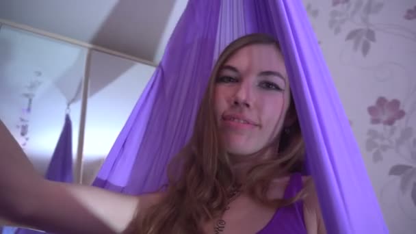 Joven mujer dispara video selfie en una hamaca púrpura — Vídeo de stock