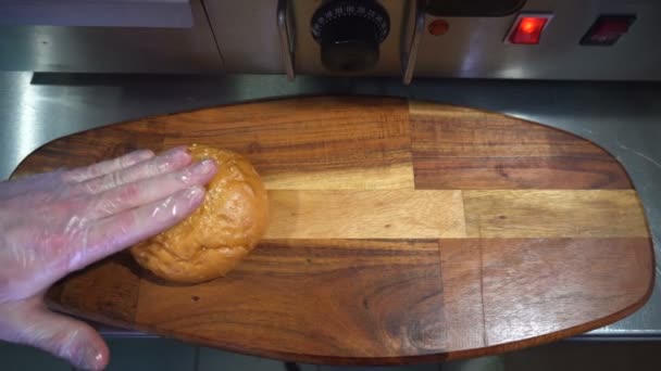 Μάγειρας που βάζει σε ένα ξύλινο δίσκο με υλικά για το μαγείρεμα ένα χάμπουργκερ — Αρχείο Βίντεο