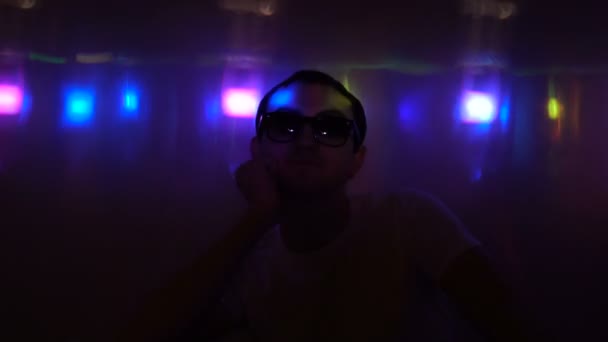 Jeune homme posant dans des lunettes de soleil à la boîte de nuit — Video