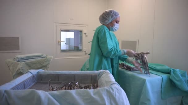 Τρίβει νοσοκόμα προετοιμασία χειρουργικά εργαλεία για τη λειτουργία — Αρχείο Βίντεο