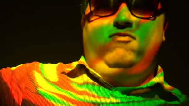 Portrait d'un homme gras dans un faisceau lumineux multicolore . — Video