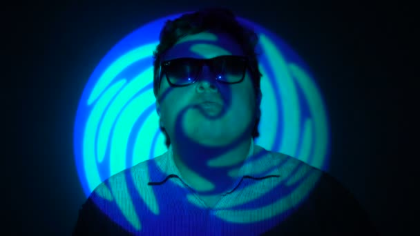 Portrait d'un homme gras dans un faisceau lumineux multicolore . — Video