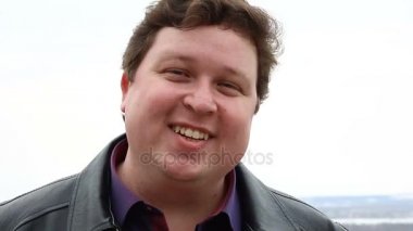 Park siyah deri ceketli beyaz şişman adam portresi.