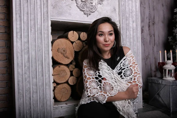 Asyalı kız onun omuzlarına şal ile şömine oturan