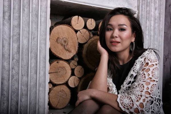 Asyalı kadın onun omuzlarına şal ile şömine oturan