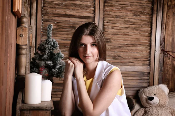 Genç bir kadın beyaz Noel beklentisiyle bir ülkede evde oturuyor