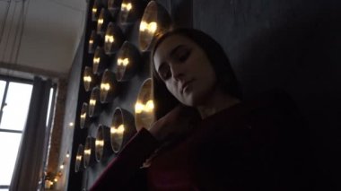 Genç kız elbise ve güçlü lambalar ile duvar bir arka plan üzerinde güzel yüz