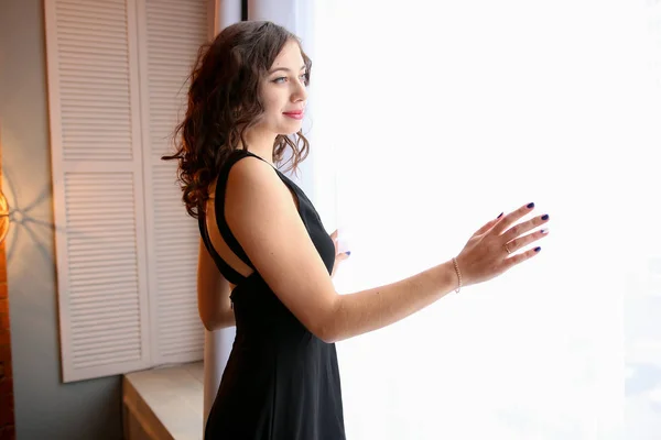 genç kadın pencereden dışarı bakar