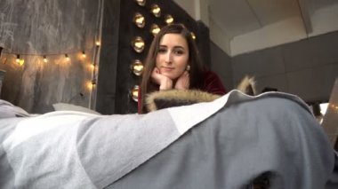 Genç ve güzel kadın elbise yalan yatak ve pozlar Studio