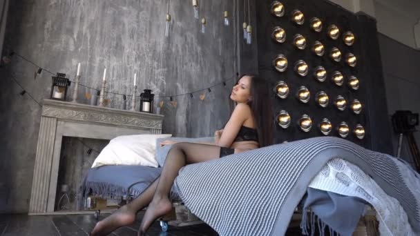 섹시 한 검은 란제리 패션 모델 여자 관능적인 침대에 앉아 — 비디오