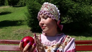 Kırmızı elma koklama Rus ulusal elbiseli kız