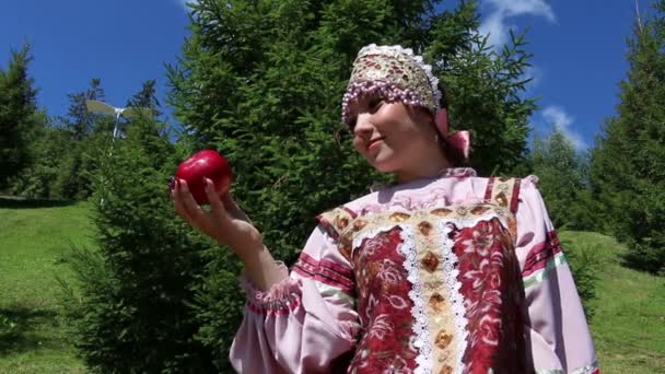Girl in Russian folk costume contemplate red apple — Stock Video