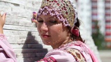 Rus takım elbiseli bir kız bir duvara yakın duruyor