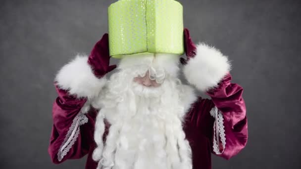 Santa Claus håller en gåva på huvudet — Stockvideo