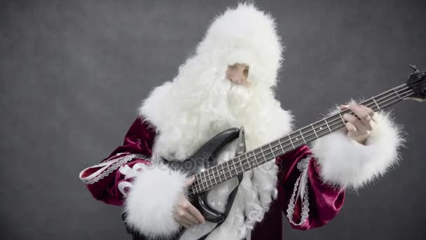 Santa claus gra melodię Boże Narodzenie jingle bells na gitarze basowej — Wideo stockowe