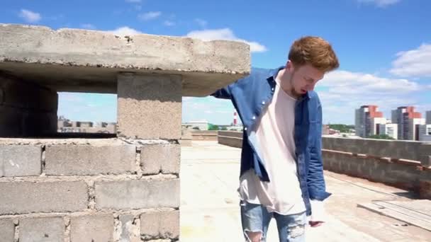 Νεαρός κοκκινομάλλα περπατήματος στη στέγη απολαμβάνουν την ελευθερία — Αρχείο Βίντεο