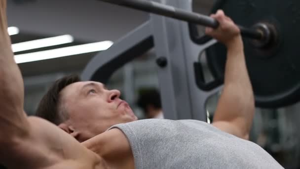 Atleta fuerte levantando la barra en el gimnasio, levantamiento de pesas, deporte — Vídeo de stock