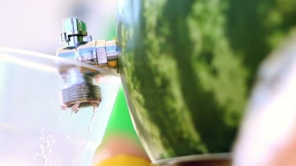 Um suco de melancia é derramado em uma torneira de uso de xícara de melancia no café de comida de rua — Vídeo de Stock