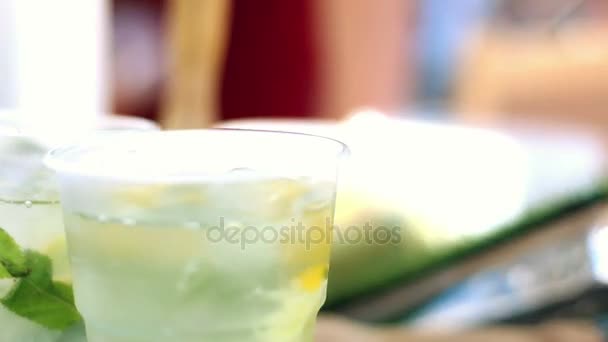 Mannenhand roeren vers limonade in glazen in een café. — Stockvideo