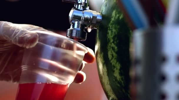Een watermeloen sap wordt gegoten in een kopje gebruik kraan van watermeloen in straatvoedsel café — Stockvideo