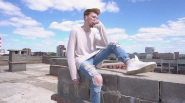 Evin çatısı kenarında oturan adam