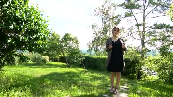 Bella modella femminile ammicca in un parco verde. Al rallentatore. Stedicam shot . — Video Stock