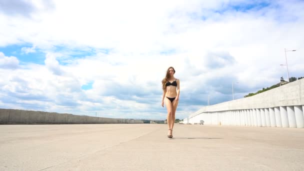Low angle shot of sexy girl walking on road in lingerie to camera — Stock Video