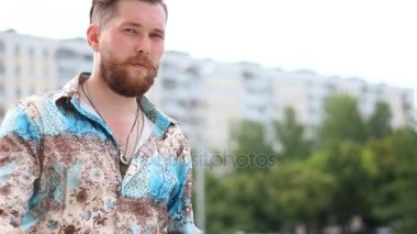 Yakışıklı genç sakallı adam açık havada kameraya bakarak gömlekli portresi