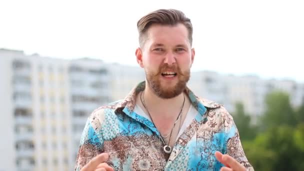 З красивого бородатого чоловіка показує круті жести на руках — стокове відео