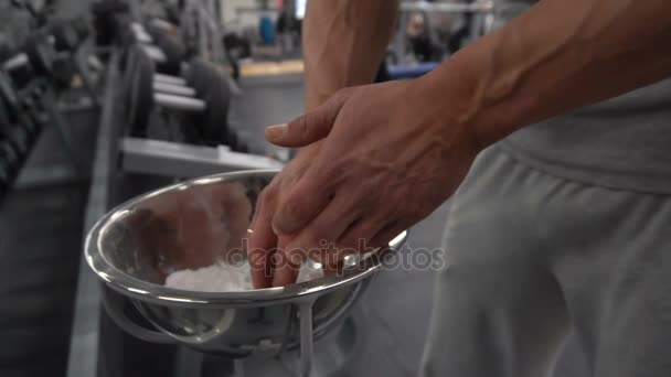Passar man kritning händerna i gymmet i slow motion — Stockvideo