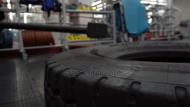 Набивает колесо кувалдой в рамках тренировки по бодибилдингу . — стоковое видео