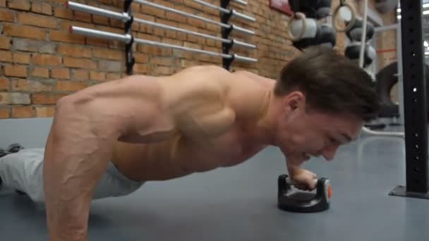 Guapo hombre de fitness haciendo flexiones en el gimnasio — Vídeos de Stock