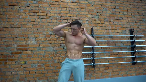 Gespierd en fit bodybuilder poseren toont de kern spieren. — Stockvideo